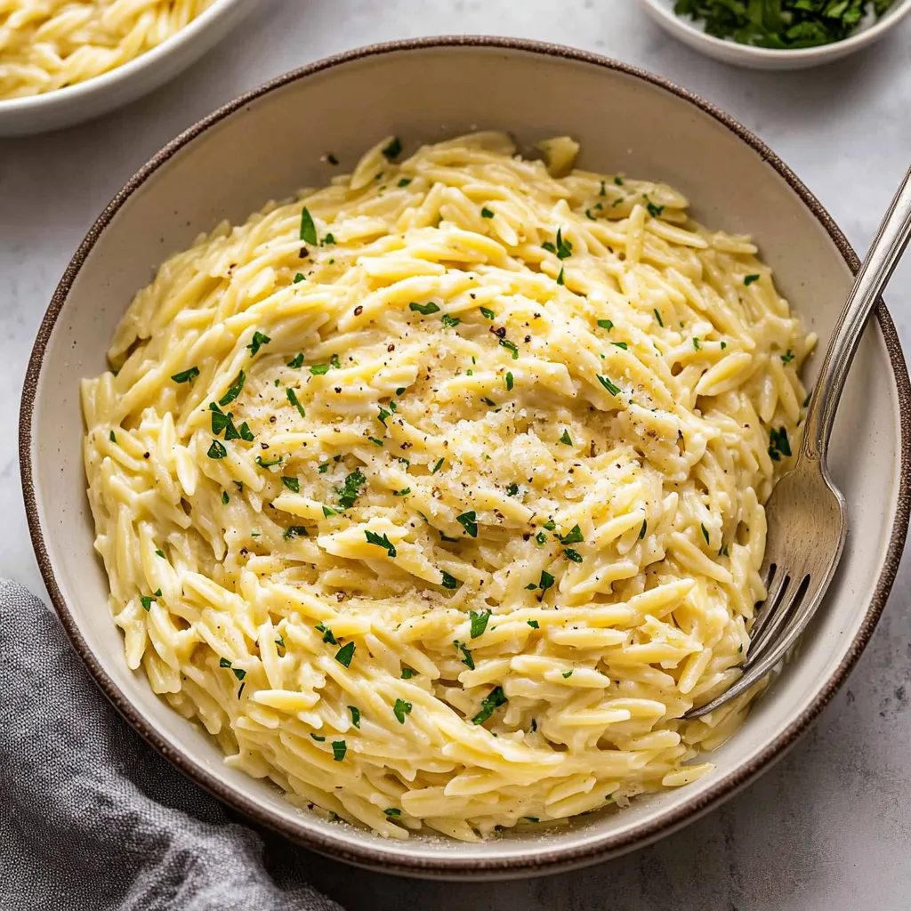 A bowl of pasta with cheese and herbs.