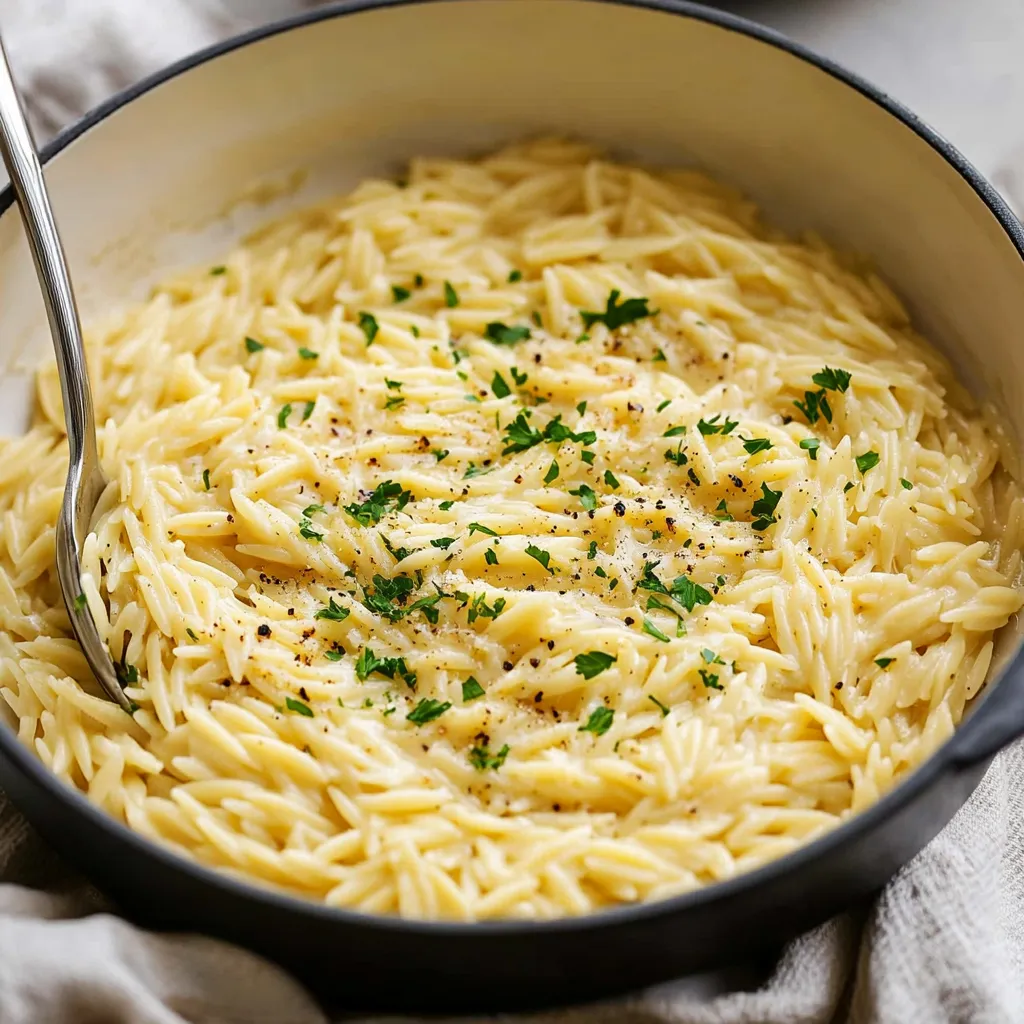A bowl of pasta with green herbs on top.